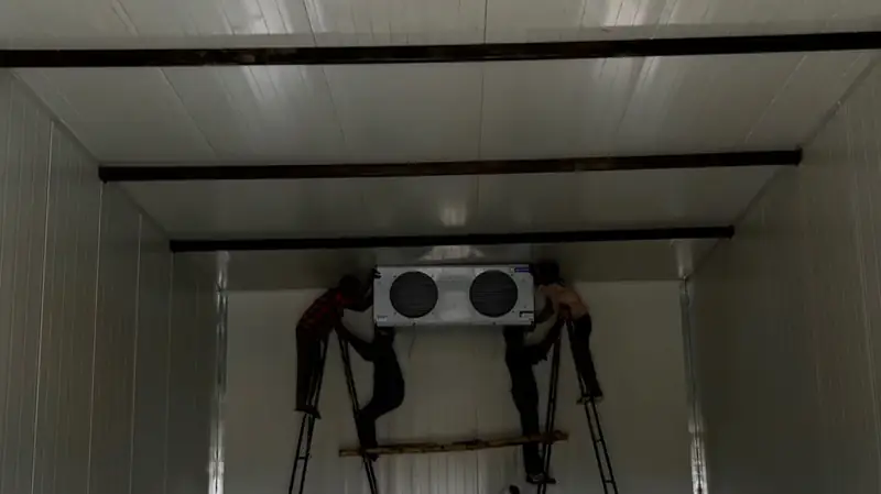 MushroomWale technicians fitting a cooling unit inside a grow room